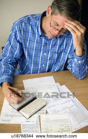 Picture - Man paying bills. Fotosearch