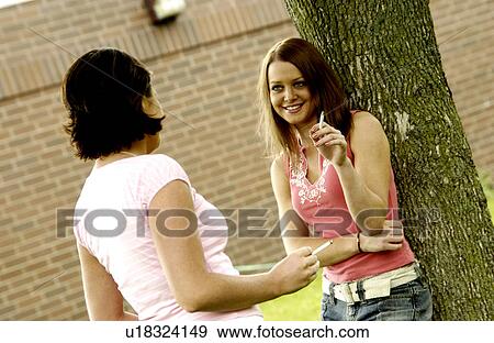Two young girls smoking View Large Photo Image Stock Photo - Two young girls smoking. Fotosearch