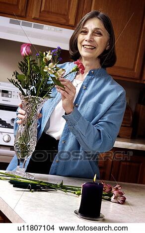 Picture - Woman arranging flowers. Fotosearch