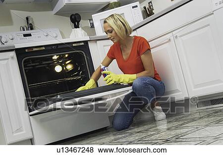 Stock Photo - Woman cleaning oven. Fotosearch