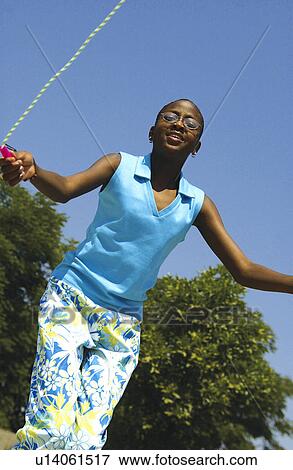 Stock Photo - African American girl jumping rope. Fotosearch