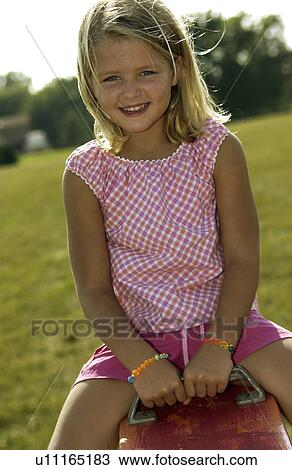 Stock Image - Girl on teeter totter. Fotosearch