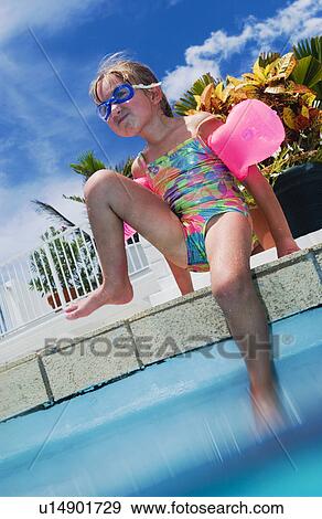 Stock Photo - Girl sitting on edge of pool. Fotosearch