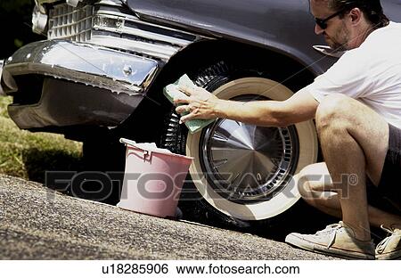 Stock Photograph - Man washing antique car. Fotosearch