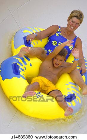 Stock Image - Mother and son on water slide. Fotosearch