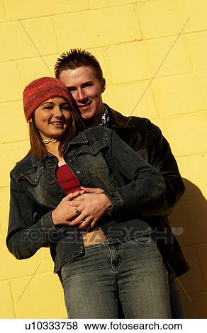 Teenagers leaning against a yellow wall View Large Photo Image Stock Photo - Teenagers leaning against a yellow wall. Fotosearch