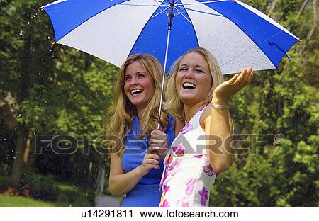 Stock Image - Two women under umbrella. Fotosearch