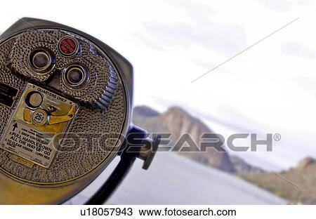 Stock Image - Binoculars overlooking desert mountains. Fotosearch