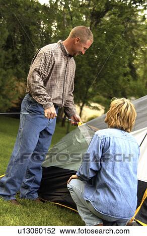 Couple putting up camping tent View Large Photo Image Stock Image - Couple putting up camping tent. Fotosearch