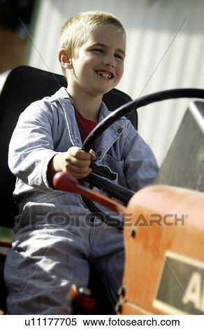 Stock Photography - Boy on tractor. Fotosearch