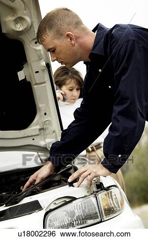 Stock Photograph - Couple with broken down car. Fotosearch