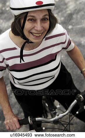 Stock Image - Senior woman bicycling. Fotosearch