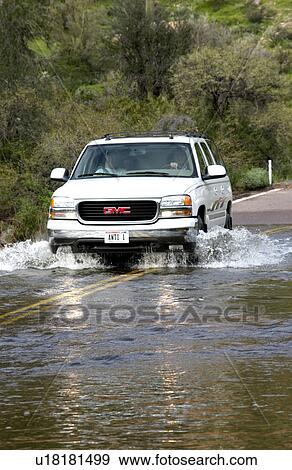 Vehicle driving on flooded road View Large Photo Image Stock Photo - Vehicle driving on flooded road. Fotosearch