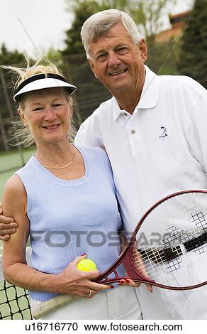 Stock Image - Senior couple playing tennis. Fotosearch