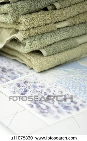 Stock Image - Towels sitting on poolside table. Fotosearch