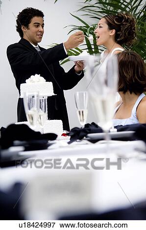 Stock Photo - Bride and groom cutting cake. Fotosearch
