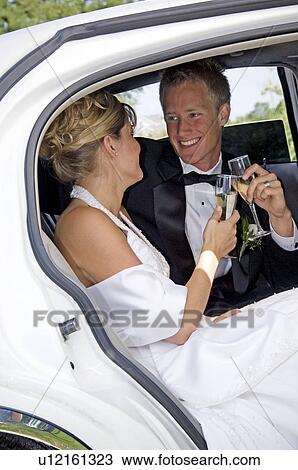 Stock Image - Bride and groom in limo. Fotosearch