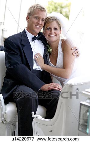 Stock Photo - Bride and groom on horse and carriage ride. Fotosearch
