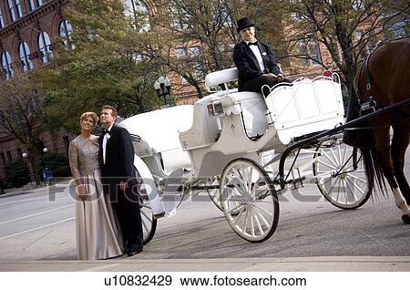 Couple in front of horse drawn carriage View Large Photo Image Stock Photo - Couple in front of horse drawn carriage. Fotosearch