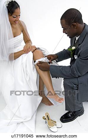 Groom taking off brides garter View Large Photo Image Stock Photography - Groom taking off brides garter. Fotosearch