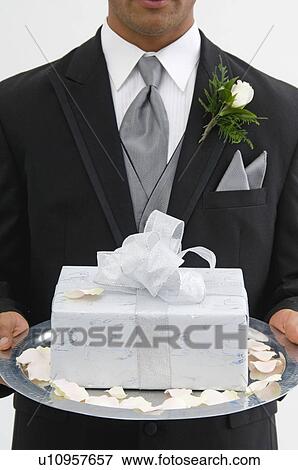 Stock Photo - Groom with gift on silver platter. Fotosearch