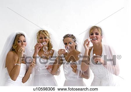 Stock Photograph - Group of brides blowing bubbles. Fotosearch