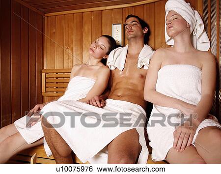 Stock Photograph - A man and two young women relaxing at a spa together. Fotosearch