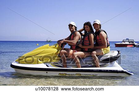 Two men and a woman on jetski View Large Photo Image Stock Photo - Two men and a woman on jetski. Fotosearch