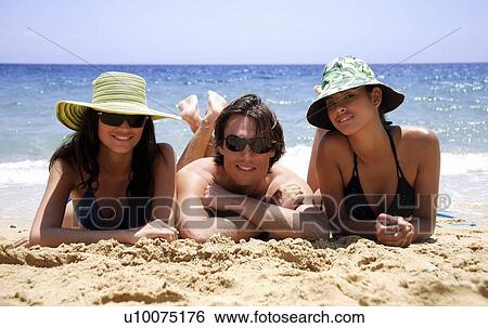 Two women and a man on the beach View Large Photo Image Stock Photograph - Two women and a man on the beach. Fotosearch
