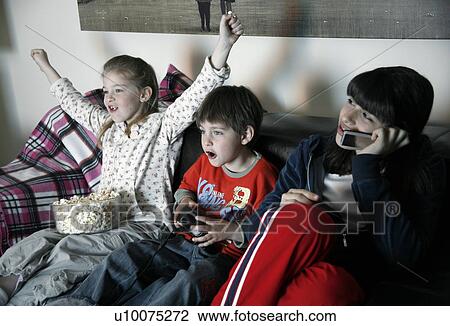 Stock Image - Young people watching television. Fotosearch