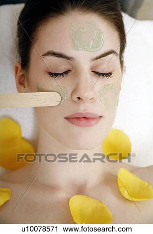 Stock Image - Woman having a facial treatment in a spa. Fotosearch
