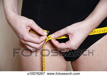Stock Photo - Woman measuring her hips. Fotosearch
