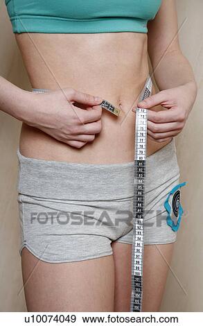 Stock Photo - Woman measuring her waist. Fotosearch