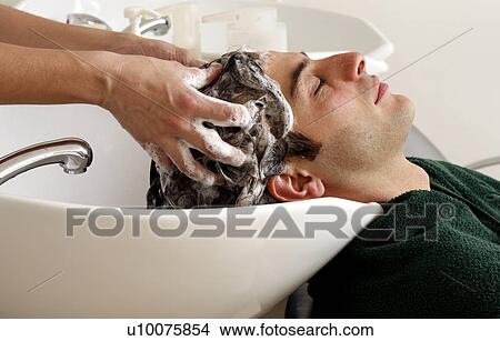 Young man having his hair washed at a salon View Large Photo Image Picture - Young man having his hair washed at a salon. Fotosearch