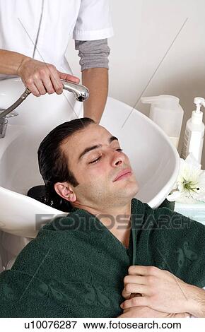 Stock Photo - Young man having his hair washed at a salon. Fotosearch