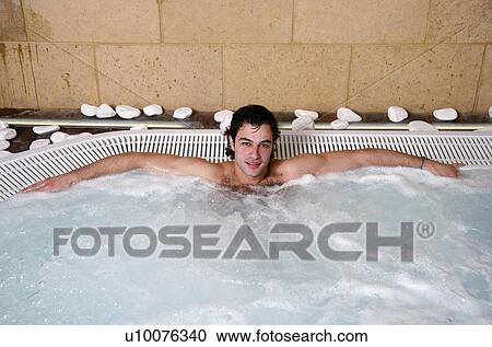 Stock Image - Young man in jacuzzi at a spa. Fotosearch