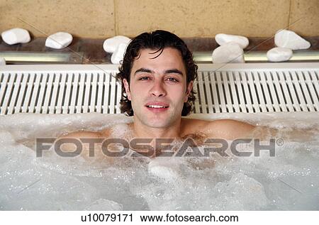 Stock Image - Young man in jacuzzi at a spa. Fotosearch