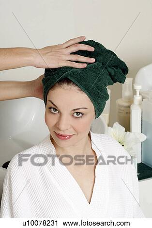 Stock Image - Young woman having her hair washed at a salon. Fotosearch
