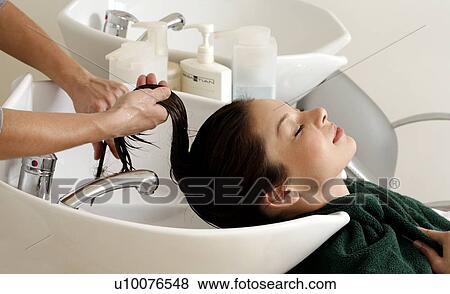Stock Photo - Young woman having her hair washed at a salon. Fotosearch