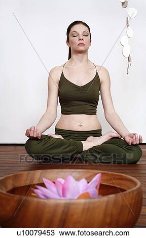 Young woman in a fitness class meditating View Large Photo Image Stock Image - Young woman in a fitness class meditating. Fotosearch