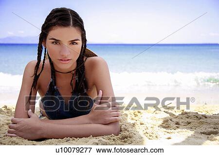 Young woman lying on beach View Large Photo Image Stock Photo - Young woman lying on beach. Fotosearch