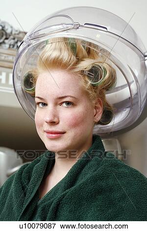 Young woman sitting under hairdryer View Large Photo Image Stock Photo - Young woman sitting under hairdryer. Fotosearch