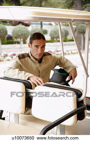 Bellboy driving hotel cart View Large Photo Image Stock Image - Bellboy driving hotel cart. Fotosearch