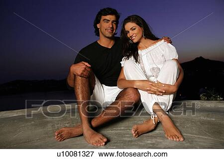 Stock Photo - Couple sitting on terrace with a view. Fotosearch