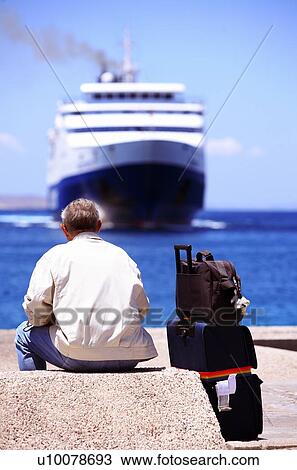 Stock Image - Man waiting for ferry at dock. Fotosearch