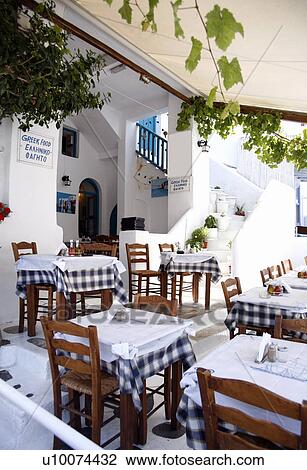 Stock Image - Tables set outside restaurant. Fotosearch