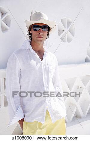 Young man in white shirt and hat View Large Photo Image Stock Image - Young man in white shirt and hat. Fotosearch