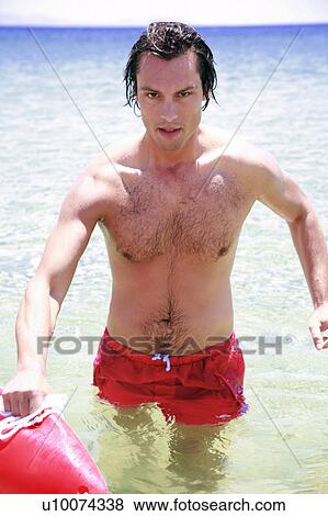 Man in water on the beach View Large Photo Image Stock Photo - Man in water on the beach. Fotosearch