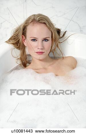 Stock Image - Woman enjoying bubble bath. Fotosearch