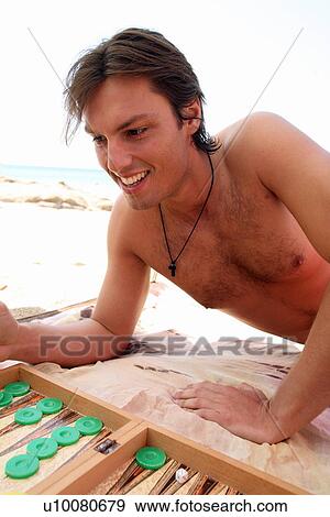 Young man on beach playing backgammon View Large Photo Image Stock Photo - Young man on beach playing backgammon. Fotosearch